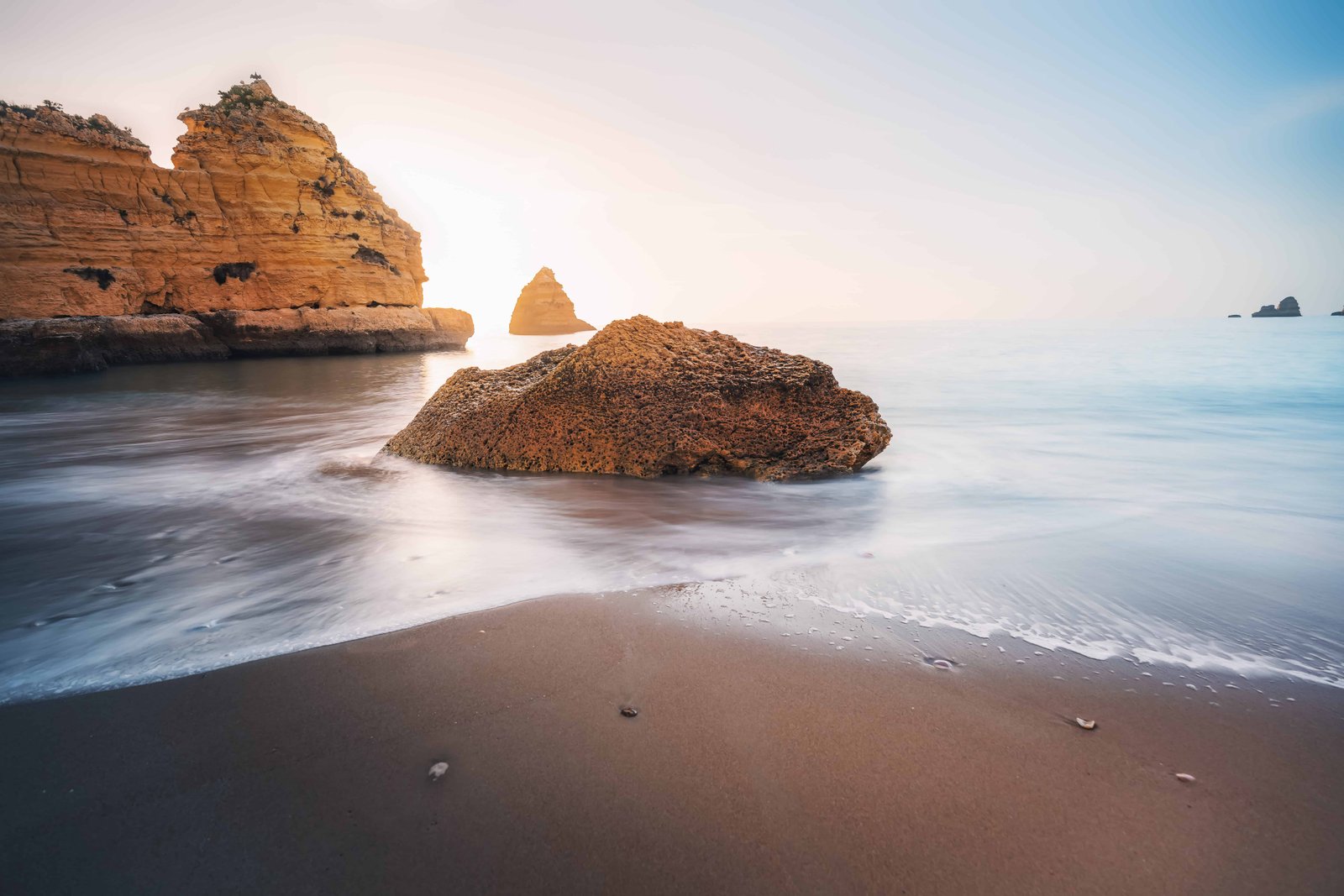 How To Visit Dona Ana Beach (Full Guide for 2026) 4 Sea Waves at Praia Dona Ana Beach with beautiful Rock formations at sunrise