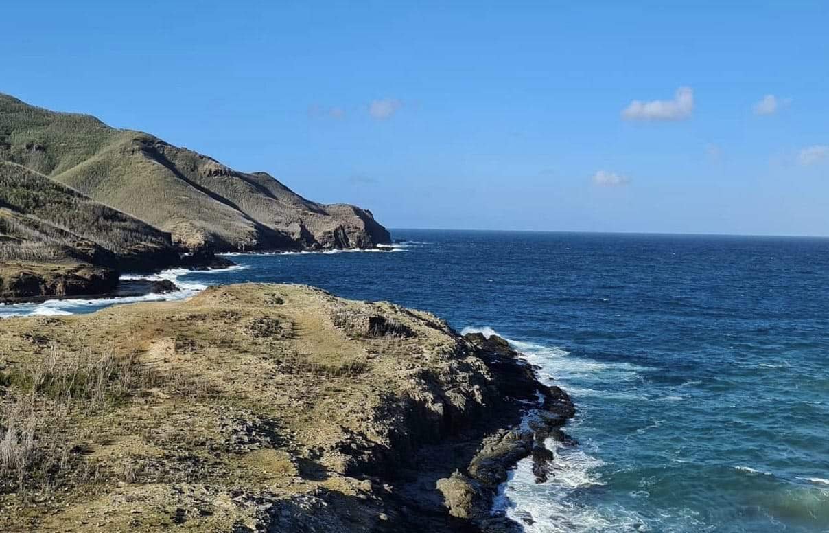 a rocky coast with waves crashing on the shore in Ua Pou