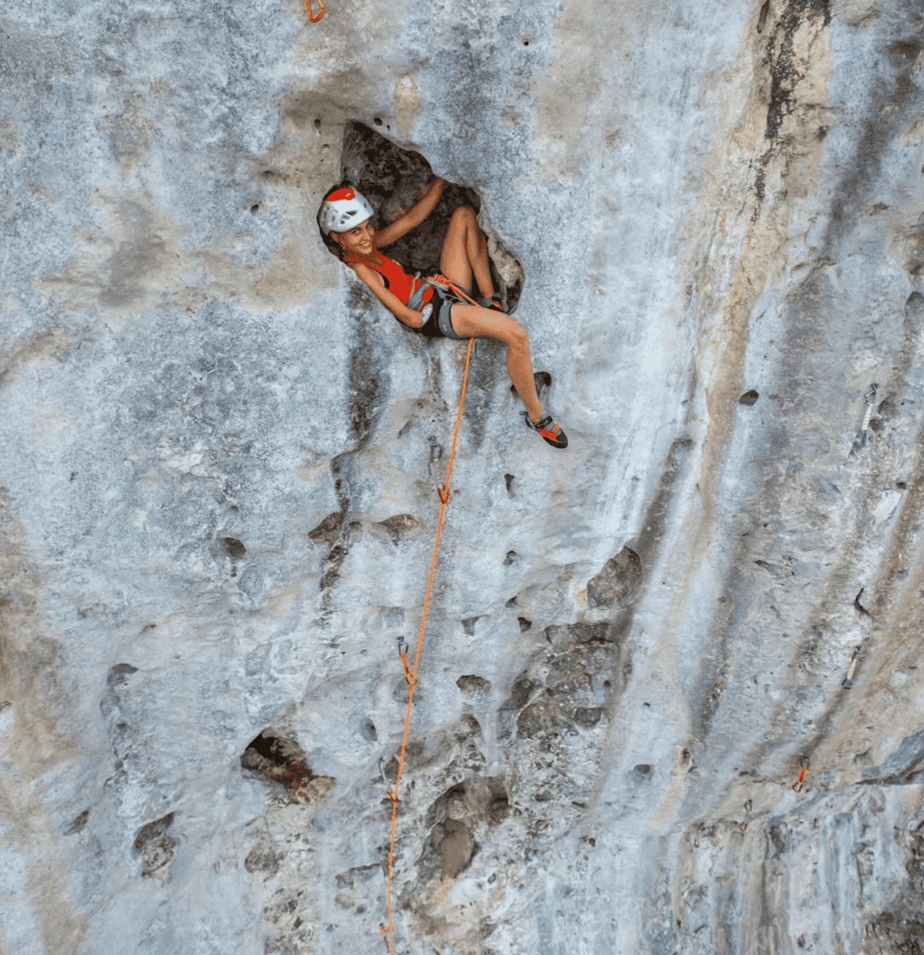 a woman climbing a rock wall at Makatea Tahiti