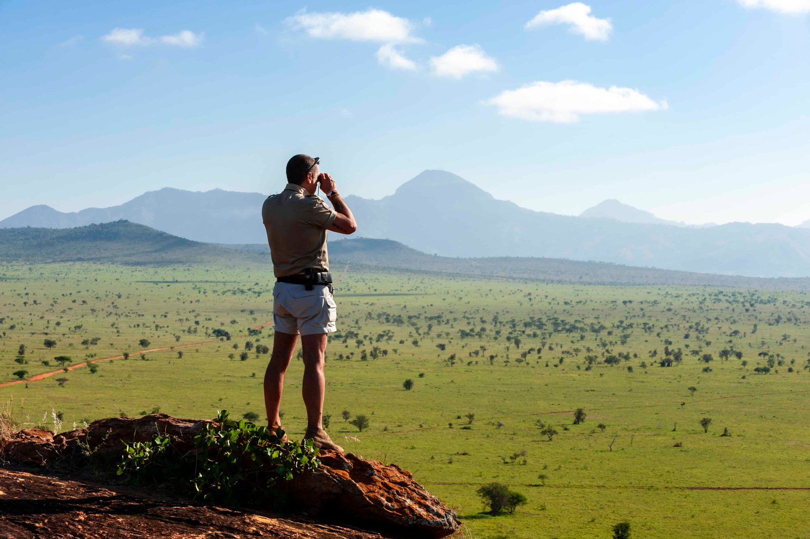 Explorer gazing across the vast savanna landscape in Kenya