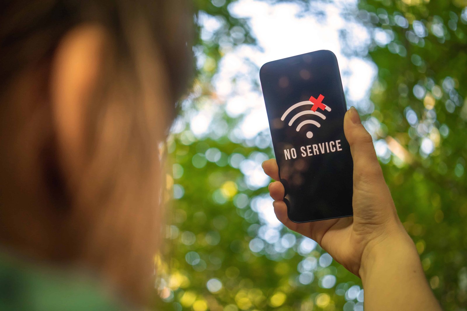 Best eSIM for International Travel (Unlimited Data + No Roaming Fees) 9 Phone against a tree with no cell service